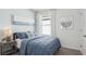 Stylish bedroom with blue bedding, coastal-themed art, and a bright window, creating a relaxing ambiance at 36029 Sunflower Hill Dr, Zephyrhills, FL 33541