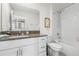 Bright bathroom with granite vanity, white cabinets, and subway tile in shower at 36412 Garden Wall Way, Zephyrhills, FL 33541