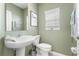 Charming bathroom with pedestal sink, decorative mirror, and ample natural light at 36412 Garden Wall Way, Zephyrhills, FL 33541