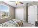 Well-lit bedroom with a window, ceiling fan, and closet with bifold doors at 36412 Garden Wall Way, Zephyrhills, FL 33541