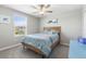 Bright bedroom boasts a ceiling fan, soft lighting, and a bright blue desk at 36412 Garden Wall Way, Zephyrhills, FL 33541