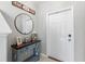 Entryway decorated with a round mirror, console table with decor, and a 'home sweet home' sign at 36412 Garden Wall Way, Zephyrhills, FL 33541