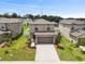 Two-story home featuring a two-car garage, manicured lawn, and tasteful landscaping at 36412 Garden Wall Way, Zephyrhills, FL 33541