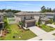 Aerial view of two-story home featuring a two-car garage and landscaped front yard at 36412 Garden Wall Way, Zephyrhills, FL 33541