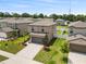 Aerial view of a two-story home featuring a two-car garage and landscaped front yard at 36412 Garden Wall Way, Zephyrhills, FL 33541