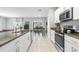 Open-concept kitchen with stainless steel appliances, granite countertops, and tile backsplash at 36412 Garden Wall Way, Zephyrhills, FL 33541