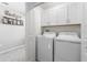 Efficient laundry room with modern appliances and upper cabinets for storage at 36412 Garden Wall Way, Zephyrhills, FL 33541