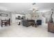Bright, open-concept living room with modern finishes and tile flooring flowing into the kitchen at 36412 Garden Wall Way, Zephyrhills, FL 33541