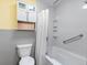 This bathroom features tiled walls, a shower with a curtain, and a toilet with an adjacent storage unit at 3944 49Th S Ave, St Petersburg, FL 33711