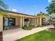 Welcoming front entrance with a tiled porch, lush landscaping, and covered carport access at 3944 49Th S Ave, St Petersburg, FL 33711