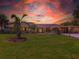 Charming single-story home with lush lawn and mature palms, bathed in a dramatic sunset at 3944 49Th S Ave, St Petersburg, FL 33711