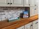 Bright kitchen boasts butcher block countertops, painted brick backsplash, and ample cabinet storage at 3944 49Th S Ave, St Petersburg, FL 33711