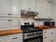 The updated kitchen features butcher block counters, modern appliances, and painted brick backsplash at 3944 49Th S Ave, St Petersburg, FL 33711