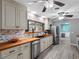 Updated kitchen with butcher block counters, stainless appliances, brick backsplash, and modern gray flooring at 3944 49Th S Ave, St Petersburg, FL 33711