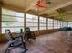 Enclosed patio with terra cotta tiles, rocking chairs, and multiple ceiling fans at 3944 49Th S Ave, St Petersburg, FL 33711