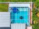 Aerial view of a screened-in pool featuring a blue umbrella and clear blue water surrounded by well-maintained landscaping at 3944 49Th S Ave, St Petersburg, FL 33711