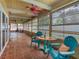 Relaxing sunroom featuring brick floors, colorful ceiling fans, and furniture for enjoying the outdoor view at 3944 49Th S Ave, St Petersburg, FL 33711