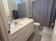 Bathroom features a single sink with vanity and a toilet with grey shower curtain at 4436 Horseshoe Pick Ln, Valrico, FL 33594