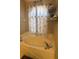 Cozy bathtub with a floral shower curtain and decorative shelves in a well-lit bathroom at 4436 Horseshoe Pick Ln, Valrico, FL 33594
