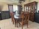 Bright dining room featuring a wooden table and chairs, with a large cabinet and tile floors at 4436 Horseshoe Pick Ln, Valrico, FL 33594