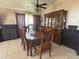 Well-lit dining room showcasing a wooden dining set, china cabinet, tile flooring and a modern ceiling fan at 4436 Horseshoe Pick Ln, Valrico, FL 33594