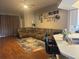 Open-concept living room with wood flooring and a large sectional sofa, open to the kitchen at 4436 Horseshoe Pick Ln, Valrico, FL 33594
