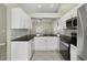 Modern kitchen boasts granite countertops, stainless steel appliances, and white cabinetry at 4607 N Country Hills Ct, Plant City, FL 33566