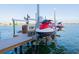 Jet skis on boat lifts with a lift control, dock, and clear blue skies in the background at 487 Harbor S Dr, Indian Rocks Beach, FL 33785