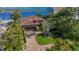 Charming home with a circular driveway, lush landscaping, and a tile roof at 487 Harbor S Dr, Indian Rocks Beach, FL 33785