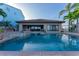 Back exterior view of the pool with a covered patio, dining table, and waterfront views at 487 Harbor S Dr, Indian Rocks Beach, FL 33785