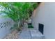 Exterior walkway featuring tropical landscaping, stone pavers, and stucco wall at 487 Harbor S Dr, Indian Rocks Beach, FL 33785