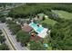 Aerial view showcases the community pool and playground surrounded by lush greenery and ponds at 5046 Gato Del Sol Cir, Wesley Chapel, FL 33544