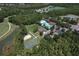 Aerial view showcases the community pool, sport court, and lake, surrounded by lush greenery at 5046 Gato Del Sol Cir, Wesley Chapel, FL 33544