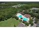 Aerial view showcases the community pool, playground, and adjacent lake, surrounded by lush greenery at 5046 Gato Del Sol Cir, Wesley Chapel, FL 33544