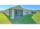 A view of the back exterior of the home showing a screened patio and a grassy backyard at 5046 Gato Del Sol Cir, Wesley Chapel, FL 33544