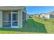 A view of the home's exterior and back lawn, with screened lanai at 5046 Gato Del Sol Cir, Wesley Chapel, FL 33544