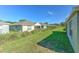 A green backyard with view of neighboring houses, some with screened lanais, under a blue sky at 5046 Gato Del Sol Cir, Wesley Chapel, FL 33544