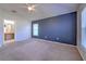 Large bedroom with carpet, a blue accent wall, a ceiling fan, and access to the bathroom at 5046 Gato Del Sol Cir, Wesley Chapel, FL 33544