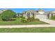 Charming single-story home featuring a well-manicured lawn, mature landscaping, and a paved driveway at 5046 Gato Del Sol Cir, Wesley Chapel, FL 33544
