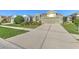 Charming single-story home with a well-manicured lawn and long driveway leading to a two-car garage at 5046 Gato Del Sol Cir, Wesley Chapel, FL 33544