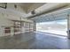 A view of the inside of the home's garage, showing storage shelves and garage door to outside at 5046 Gato Del Sol Cir, Wesley Chapel, FL 33544