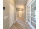 Hallway with wood floors, white doors, and natural light, offering a view of the front door at 5046 Gato Del Sol Cir, Wesley Chapel, FL 33544