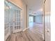 Hallway with wood floors, white doors, and natural light, offering a view into the living room at 5046 Gato Del Sol Cir, Wesley Chapel, FL 33544