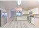 Spacious kitchen with stainless steel appliances, granite countertops, white cabinets, and modern flooring at 5046 Gato Del Sol Cir, Wesley Chapel, FL 33544