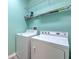 Cozy laundry room features a washer, dryer, wire shelving, and freshly painted walls at 5046 Gato Del Sol Cir, Wesley Chapel, FL 33544