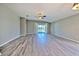 Spacious living room with sliding glass doors to backyard and gray wood-look floors at 5046 Gato Del Sol Cir, Wesley Chapel, FL 33544