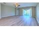 Open living room with sliding glass doors to backyard and gray wood-look floors at 5046 Gato Del Sol Cir, Wesley Chapel, FL 33544