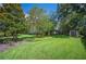 Large, well-maintained backyard with lush green grass, mature trees, and a storage shed, perfect for outdoor enjoyment at 511 Duque Rd, Lutz, FL 33549