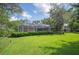 Lush backyard with a screened-in porch, mature trees, and manicured hedges surrounding the well-maintained lawn at 511 Duque Rd, Lutz, FL 33549