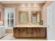 Bathroom featuring double sinks with wooden vanity, granite counter and framed mirrors at 511 Duque Rd, Lutz, FL 33549
